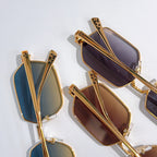 Gold-tone sunglasses with tinted lenses, open-angle view of temples