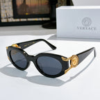 Black cat-eye sunglasses with round lenses and gold-tone accents on temples