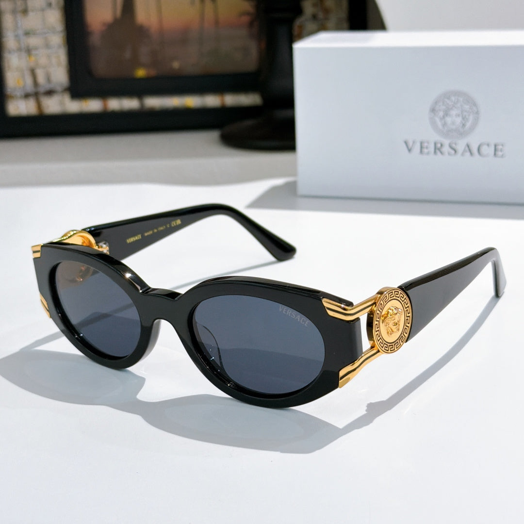 Black cat-eye sunglasses with round lenses and gold-tone accents on temples