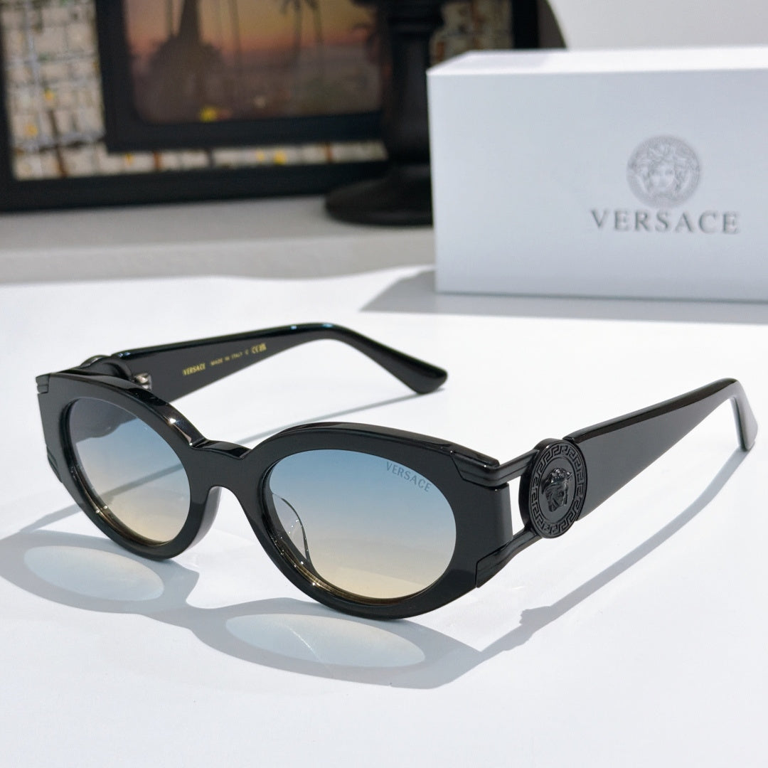 Black cat-eye sunglasses with round lenses and gold emblem on the temple