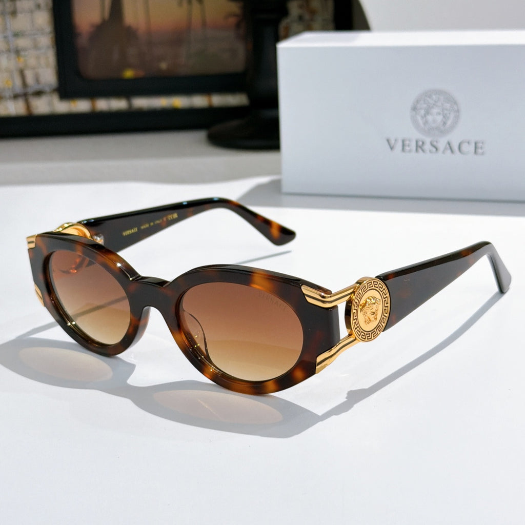 Tortoiseshell cat-eye sunglasses with round lenses and gold medallion on temple