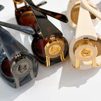 Set of sunglasses with gold emblem temple details in dark and cream frames