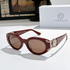 Burgundy cat-eye sunglasses with round lenses and silver emblem on the temple