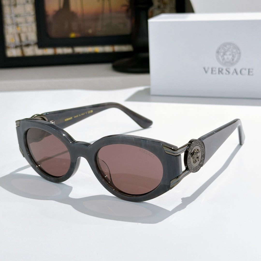 Dark blue cat-eye sunglasses with round lenses and gold emblem on the temple