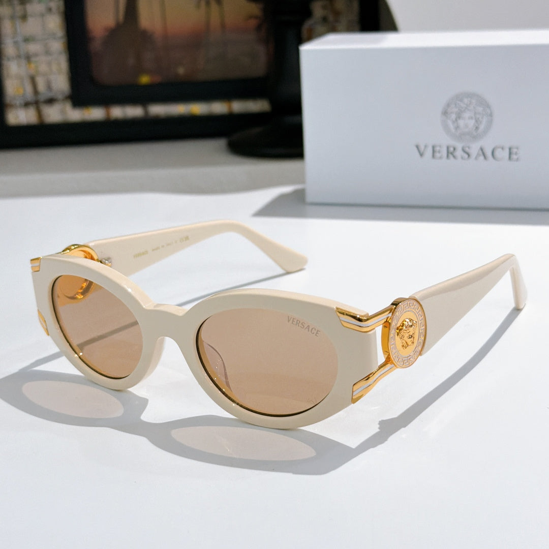 Cream cat-eye sunglasses with round lenses and gold emblem on the temple