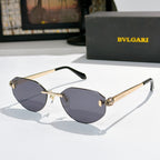 Gold-tone metal sunglasses with dark gray lenses, cat-eye frame, logo at temples