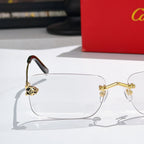 Cartier glasses with clear lenses, gold hinges, and dark red temple inserts