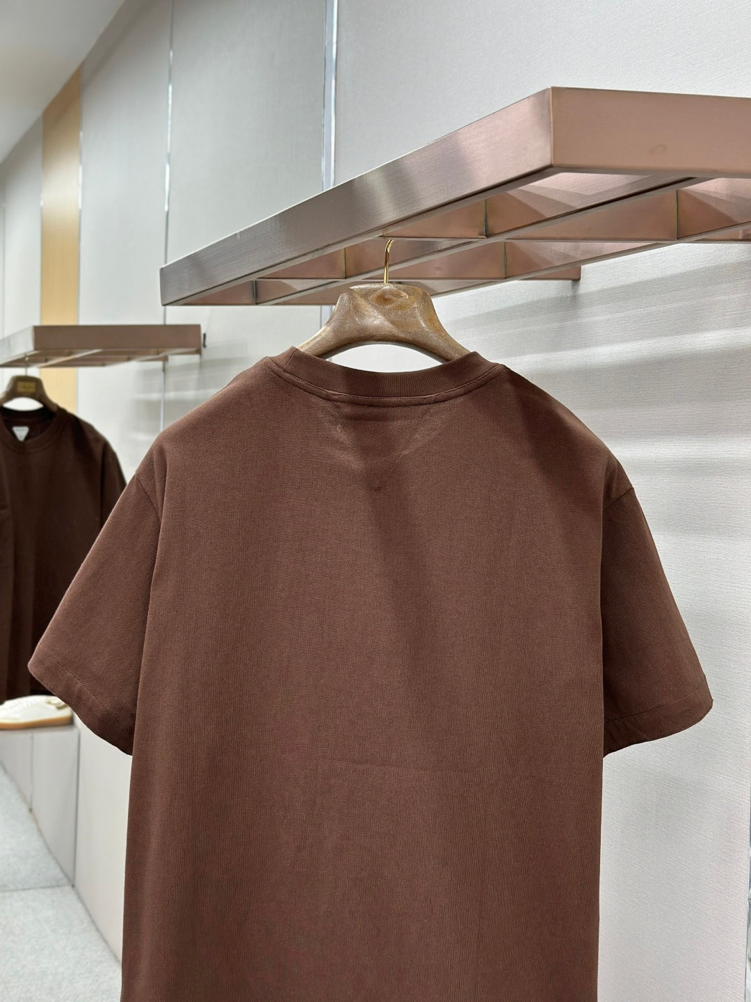 Brown crew-neck short-sleeve T-shirt, back view on hanger