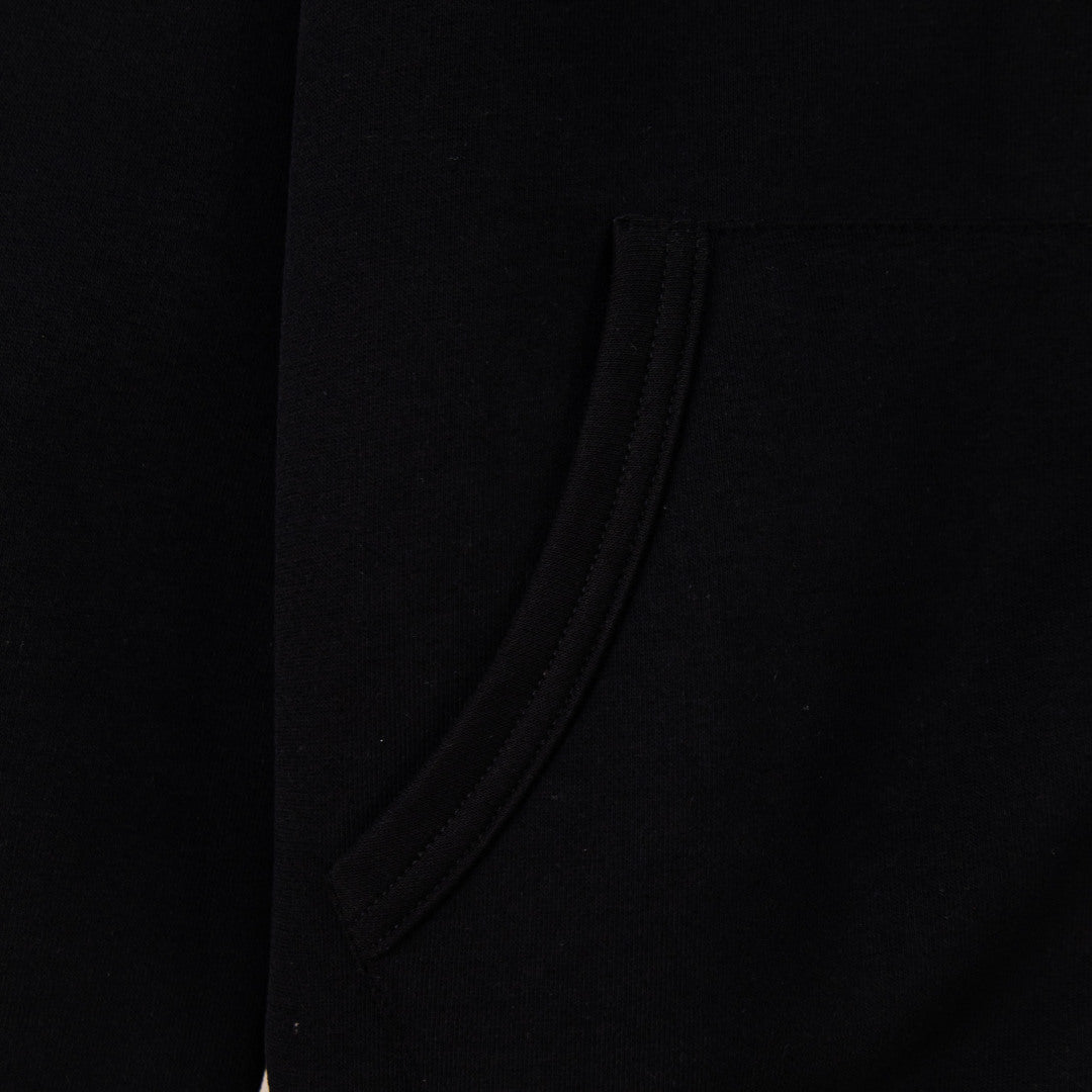 Black hoodie side view with smooth fabric and curved seam near pocket