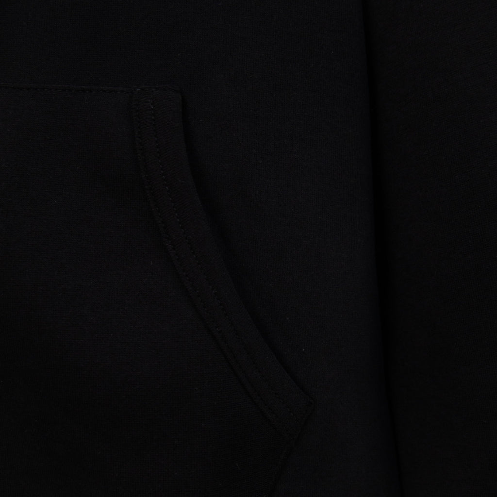 Black hoodie detail of diagonal seam and pocket line at midsection