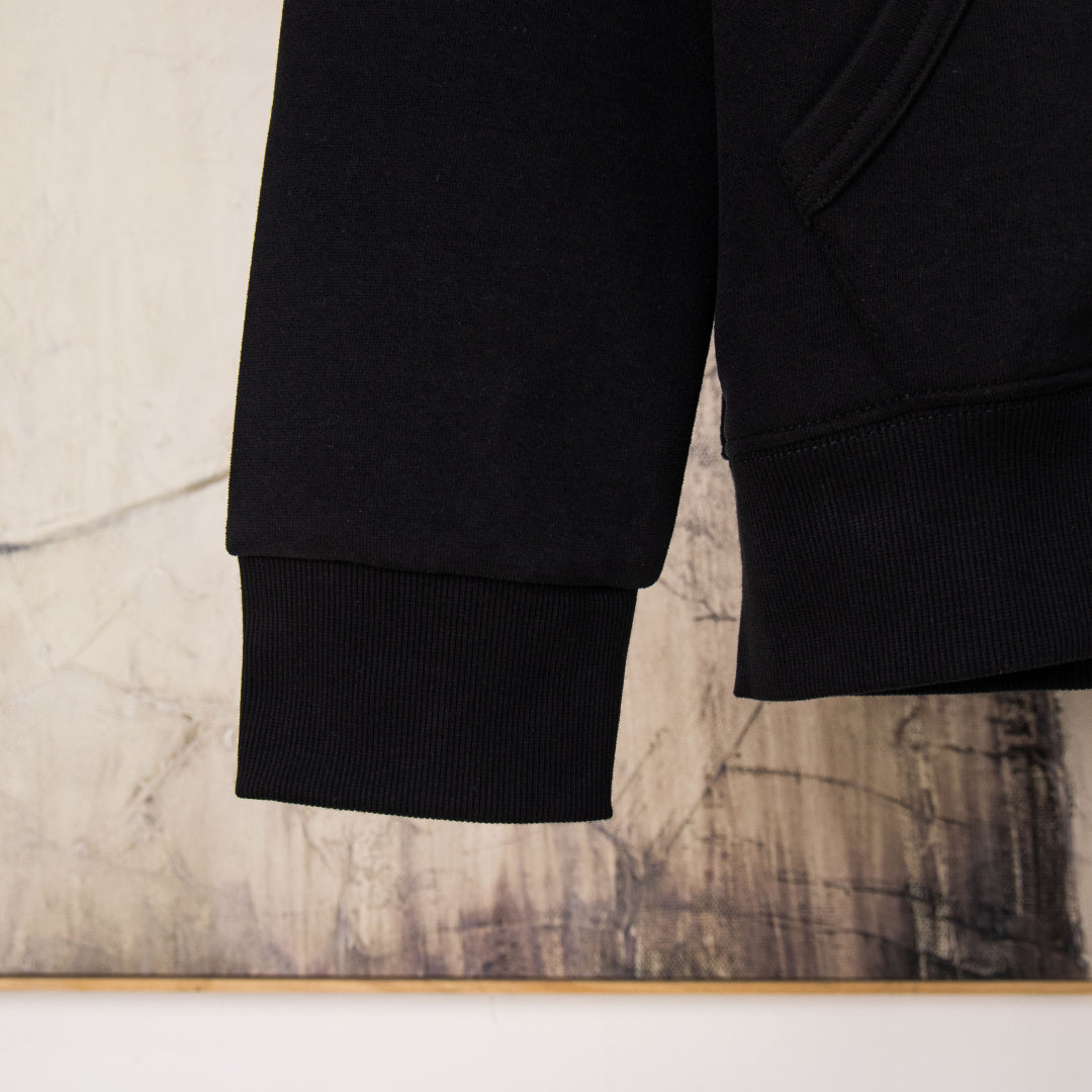 Black hoodie lower sleeve with ribbed cuffs at wrist