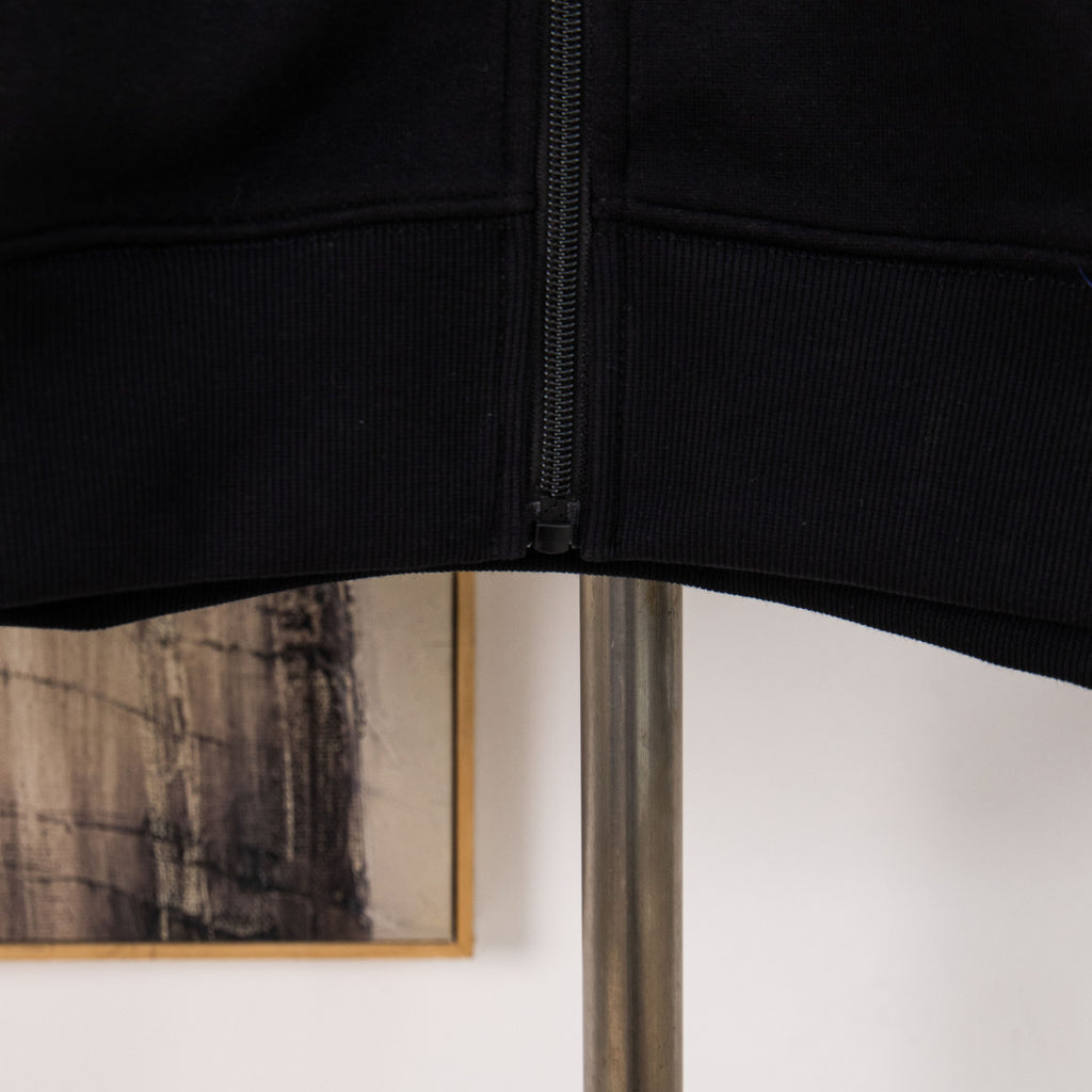 Black hoodie hem with ribbed waistband and front zipper seam