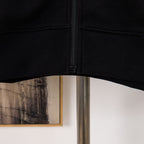 Black hoodie hem with ribbed waistband and front zipper seam