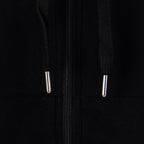 Black hoodie close-up of two silver zipper pulls on the front opening