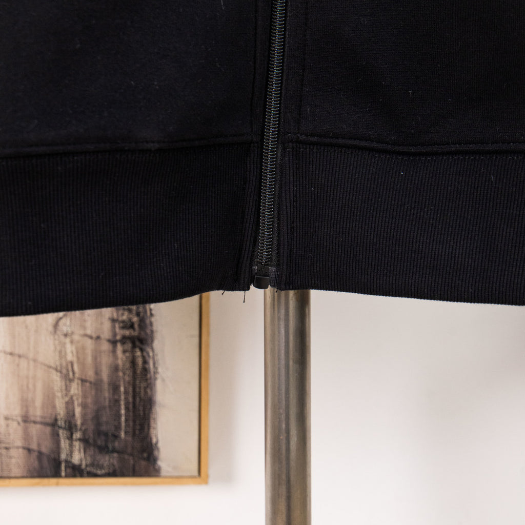 Black hoodie hem with front zipper visible at center