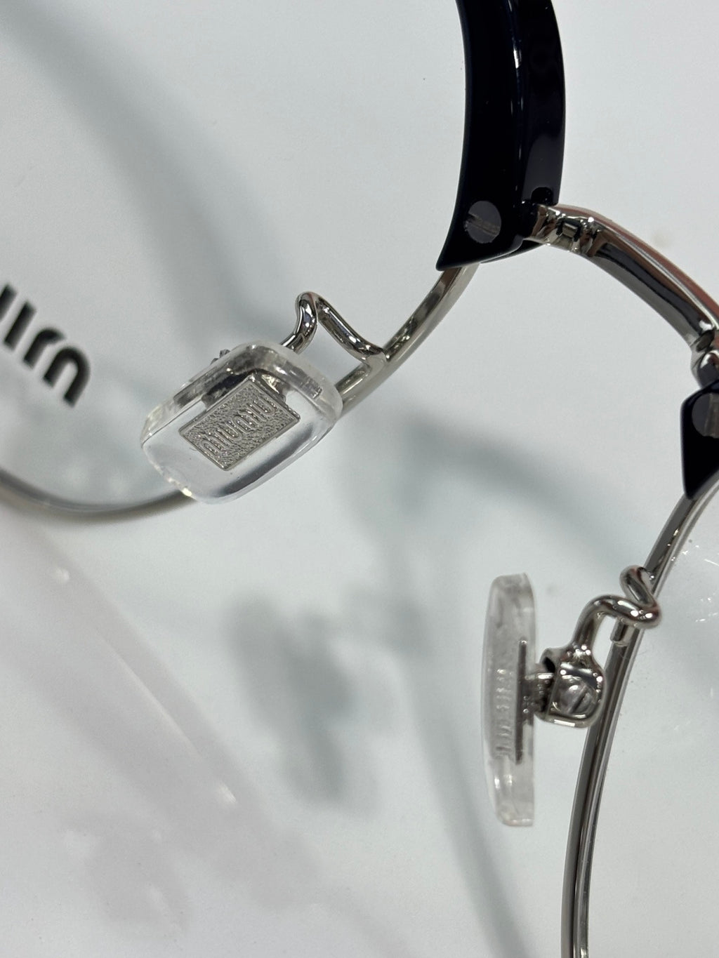 MiuMiu eyeglasses close-up of metal temple hinge and clear lens rim