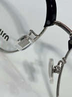 MiuMiu eyeglasses close-up of metal temple hinge and clear lens rim