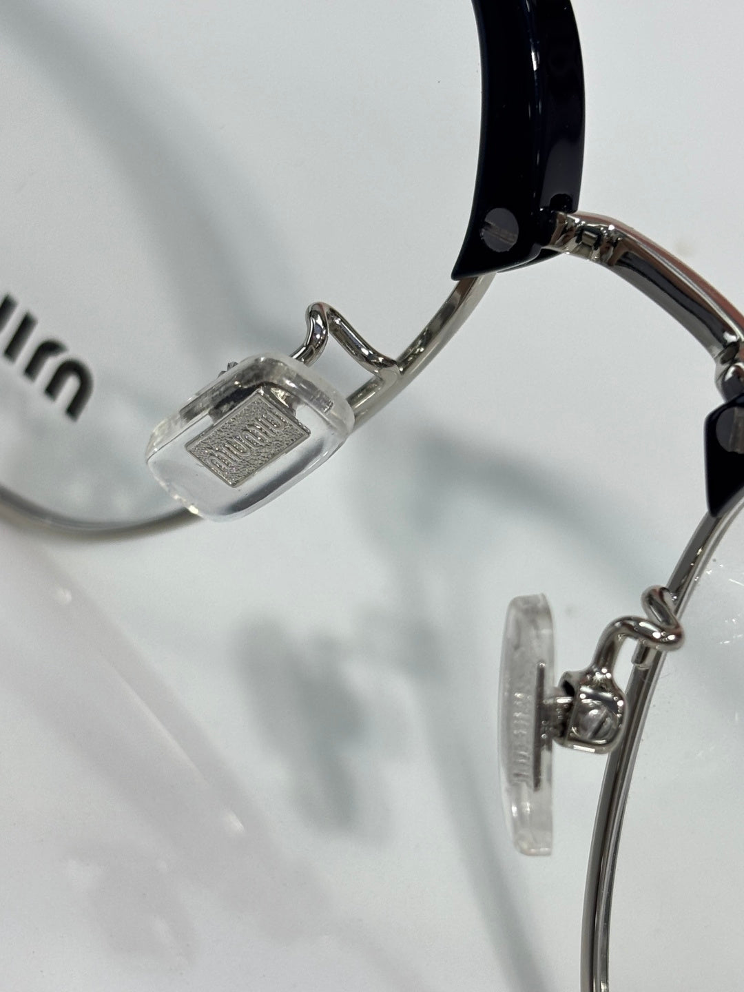MiuMiu eyeglasses close-up of metal temple hinge and clear lens rim