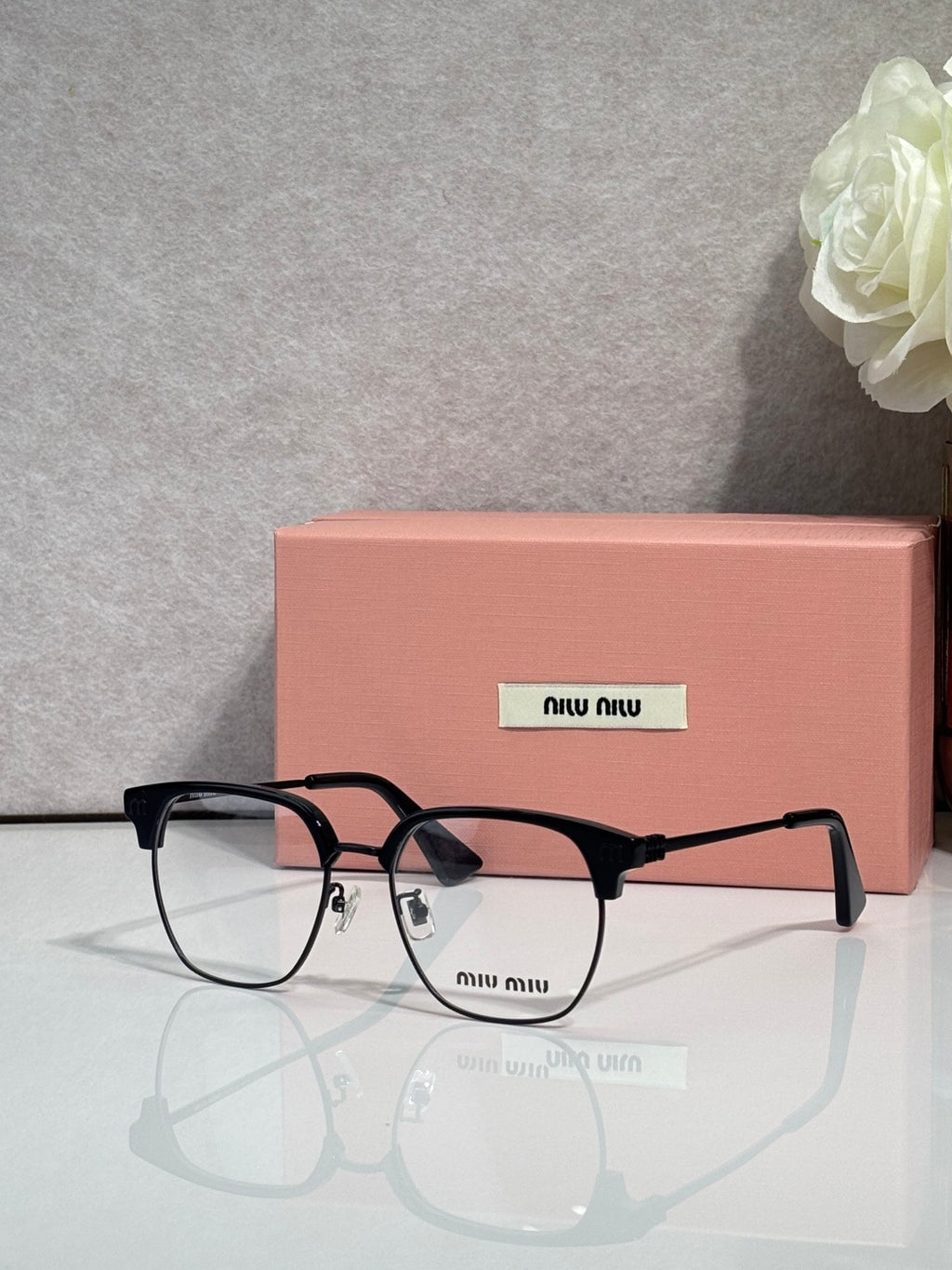 MiuMiu eyeglasses with black full-rim frame and clear lenses, arched bridge