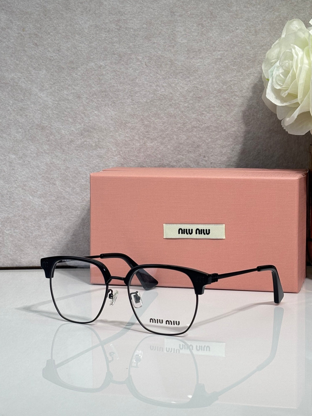 MiuMiu eyeglasses with black full-rim frame and clear lenses, arched bridge
