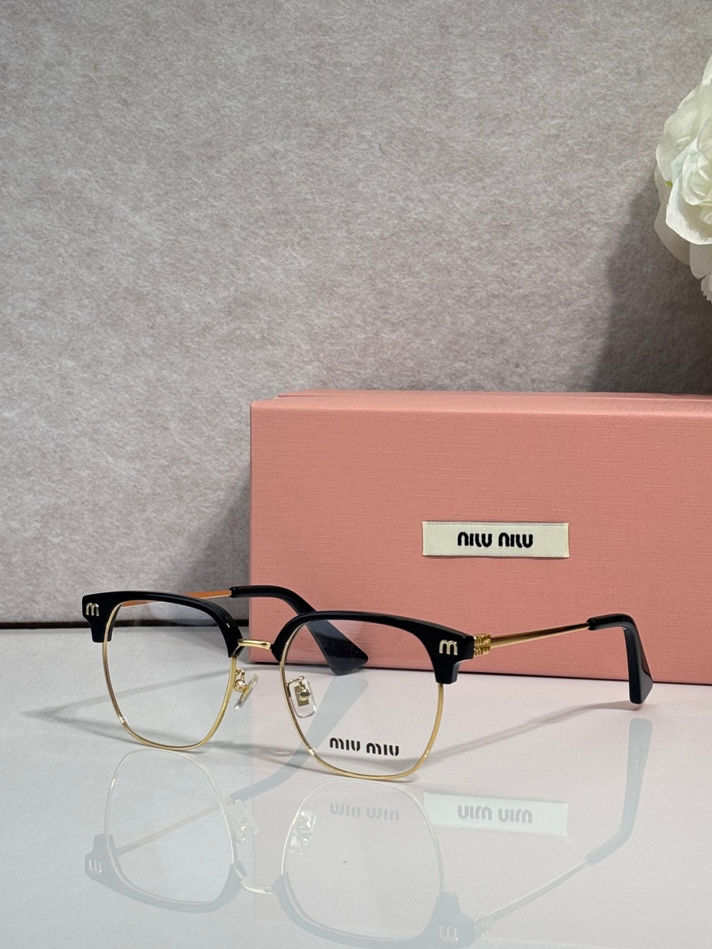 MiuMiu eyeglasses with black full-rim frame and tortoiseshell temples, clear lenses