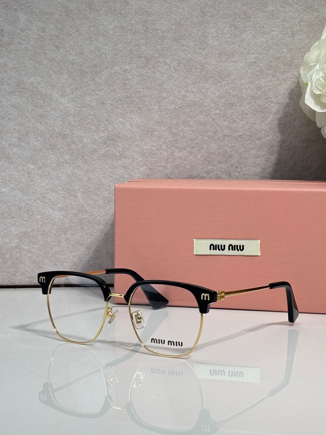 MiuMiu eyeglasses with black full-rim frame and tortoiseshell temples, clear lenses