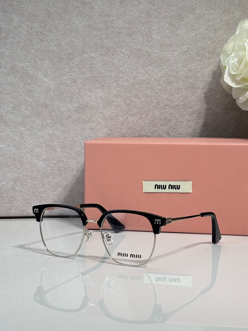 MiuMiu eyeglasses with black frame and tortoiseshell temple tips, clear lenses