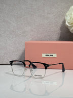 MiuMiu eyeglasses with black frame and tortoiseshell temple tips, clear lenses