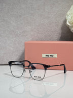 MiuMiu eyeglasses with black full-rim frame, tortoiseshell brow bar, clear lenses