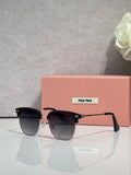 MiuMiu sunglasses with black oversized frames, dark lenses, and pink temple tips