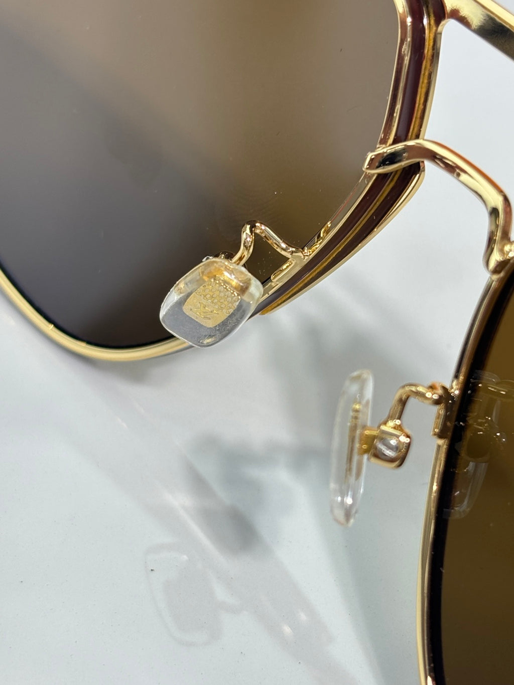 Louis Vuitton sunglasses close-up of gold hinge and temple detail with lens frame