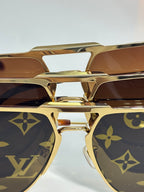 Louis Vuitton sunglasses close-up of gold frame and dark lenses with monogram pattern