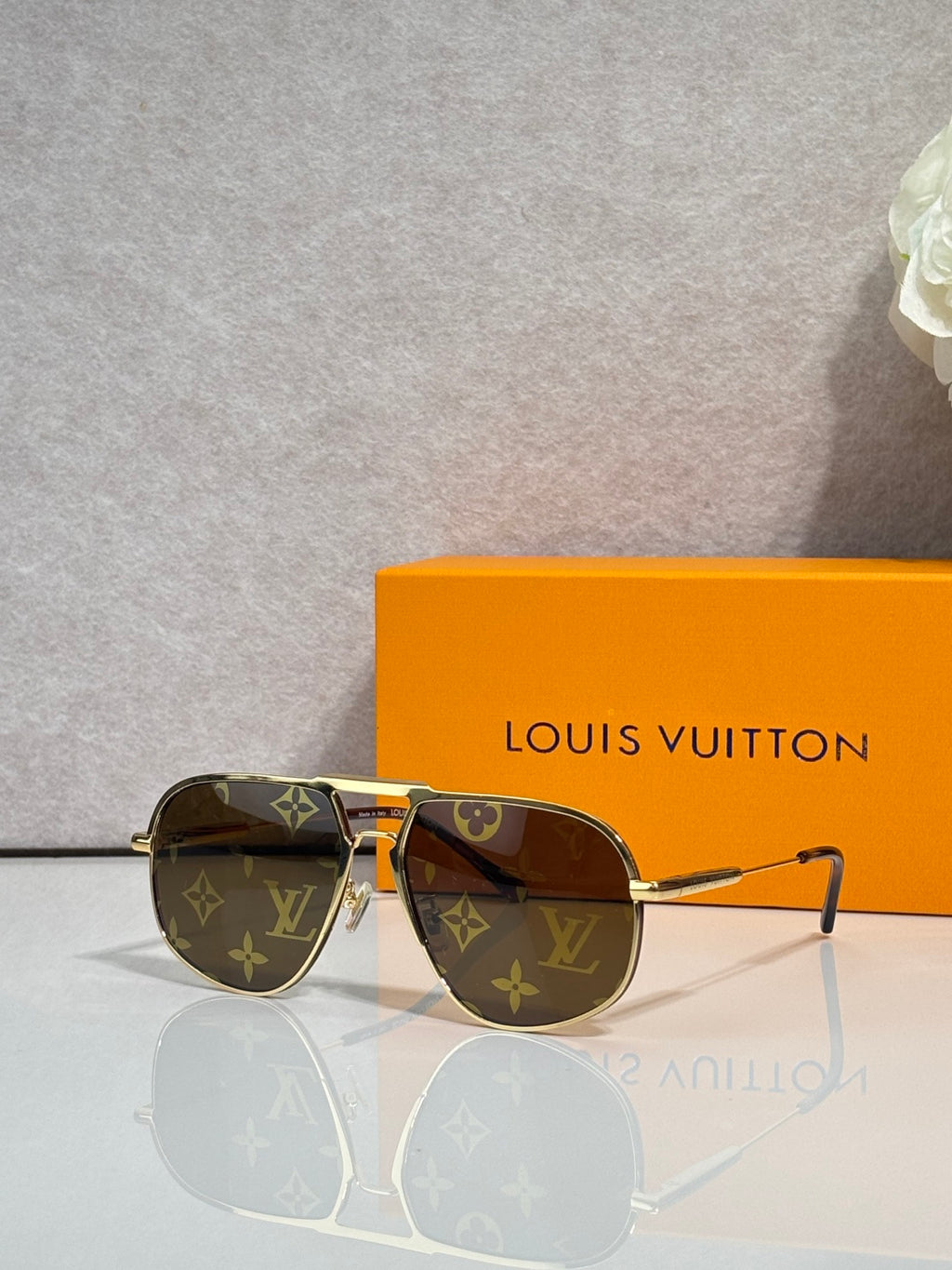 Louis Vuitton sunglasses with gold-tone frame, dark lenses, LV monogram accents