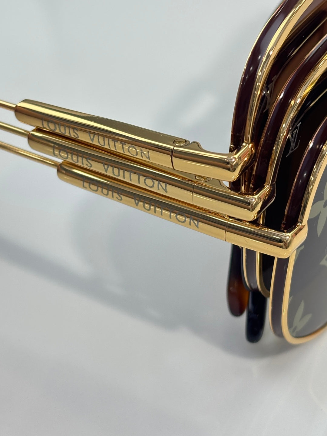 Louis Vuitton sunglasses close-up of gold temple hinge with engraved brand markings