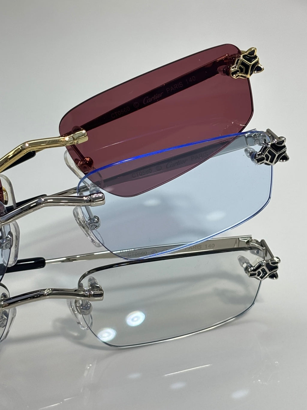 Gold-trim eyeglasses with maroon-tinted lens and clear lower lens