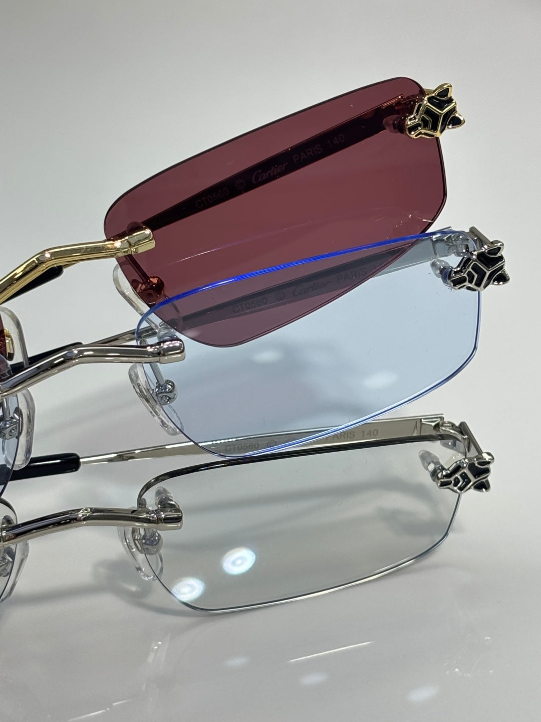 Gold-trim eyeglasses with maroon-tinted lens and clear lower lens