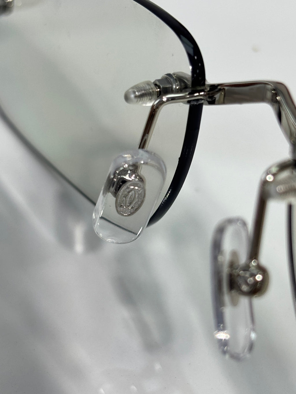 Close-up of metal eyeglass temple with clear lens and black frame piece