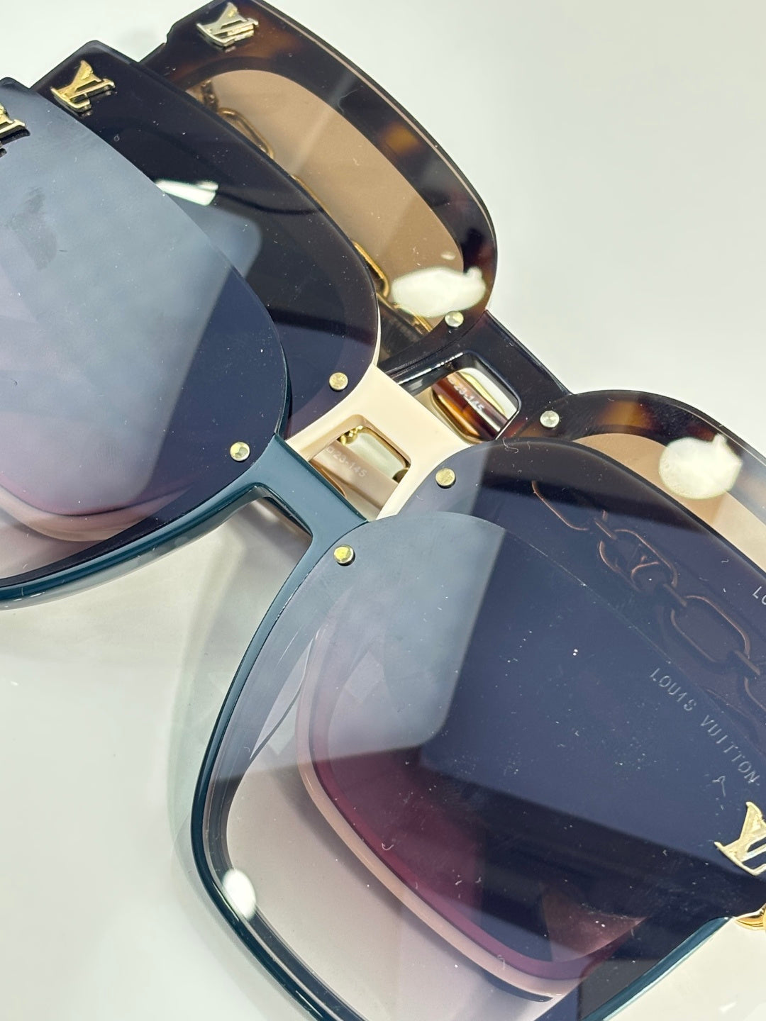 Louis Vuitton sunglasses close-up with dark lenses and gold screws on tortoiseshell frame