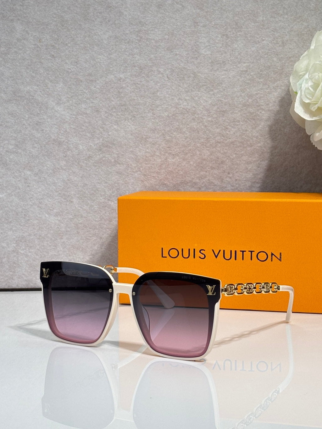 Louis Vuitton sunglasses with tortoiseshell frame and purple-tinted lenses, gold hardware