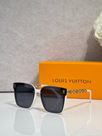 Louis Vuitton sunglasses with dark frames and gold chain detail across the temples