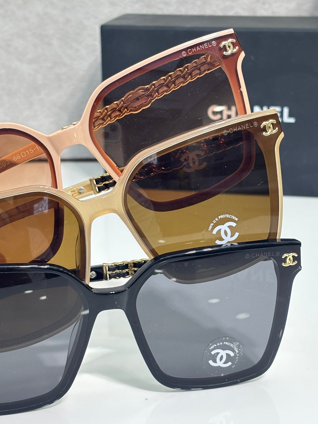 CHANEL sunglasses close-up: stacked frames with gold chain temple details