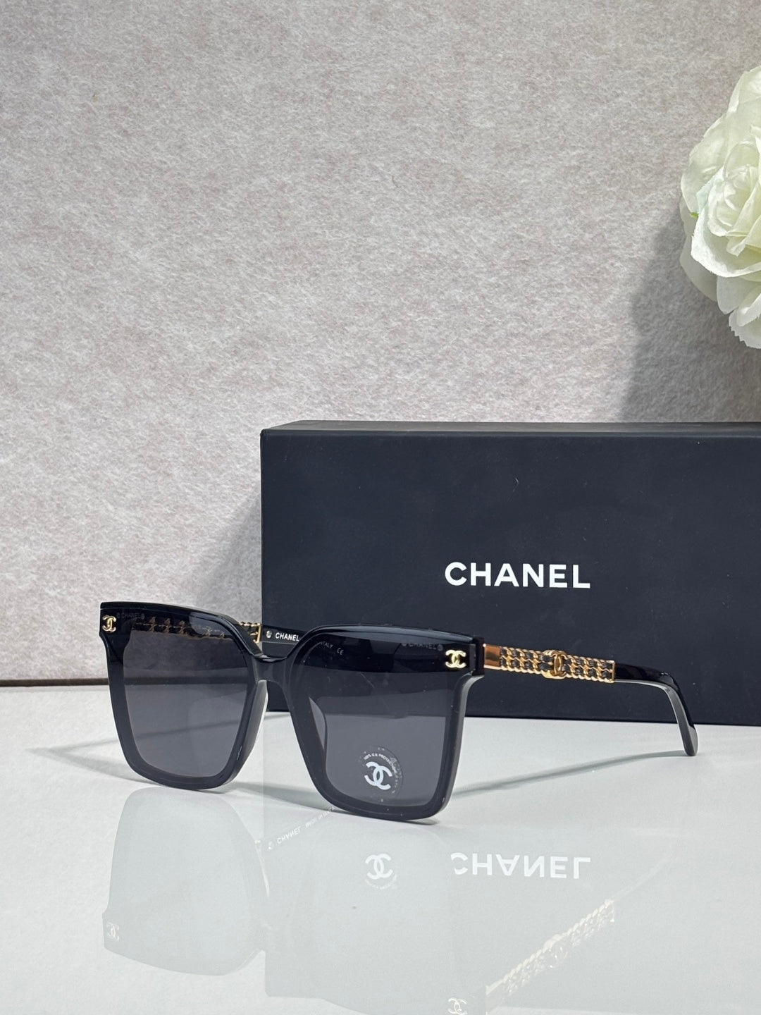 CHANEL sunglasses with dark lenses and gold chain-style temple accents