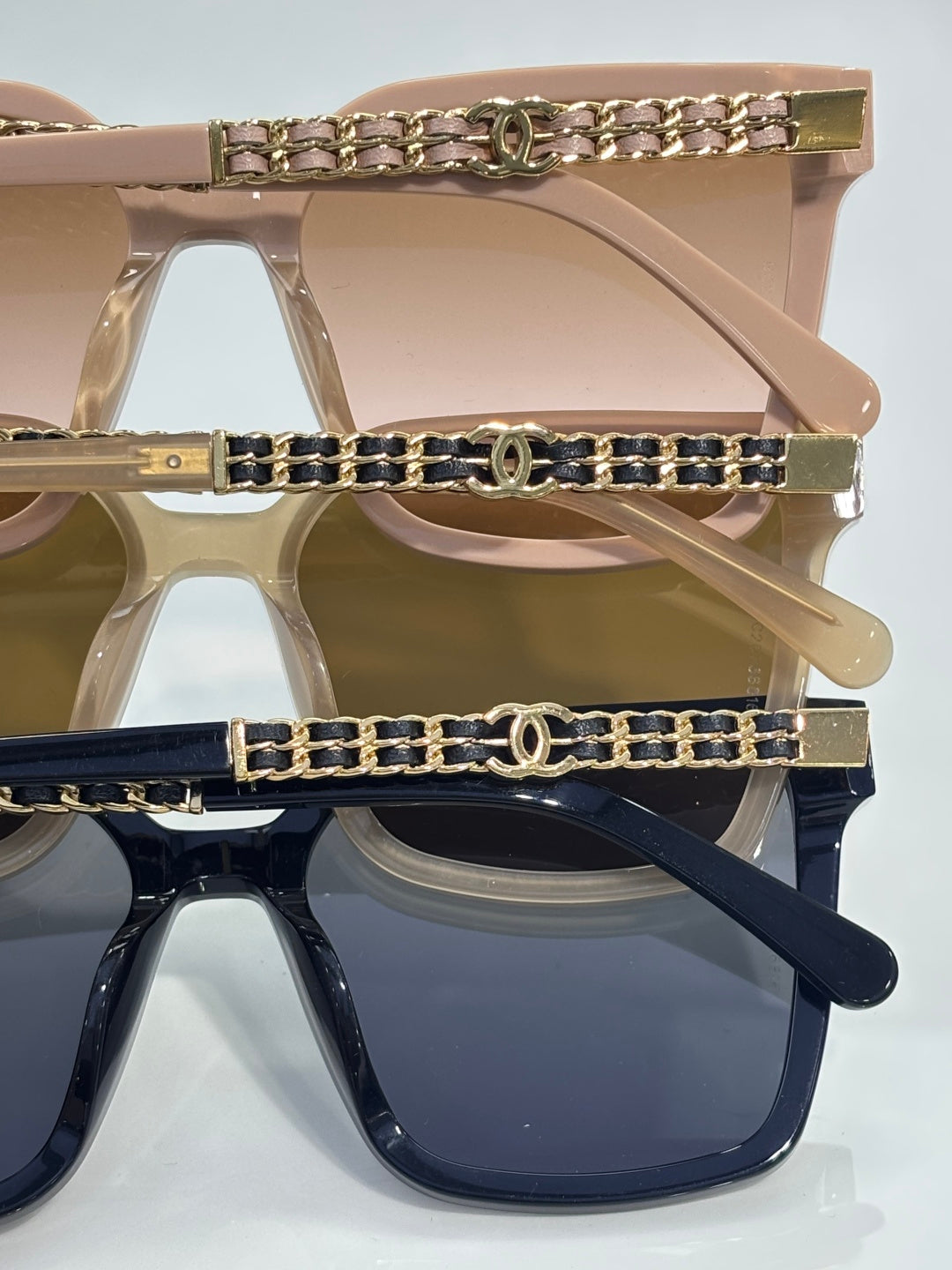 CHANEL sunglasses close-up: clear and navy frames with gold chain accents