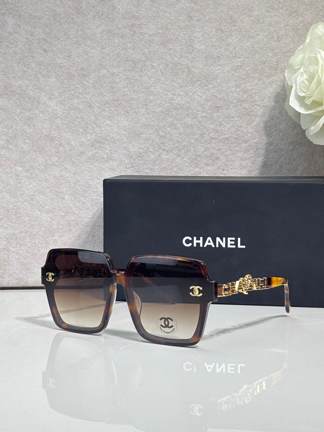 Chanel sunglasses with dark brown tortoise-effect square frames and gold-tone logo
