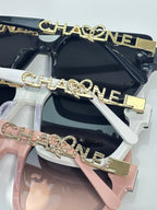 Chanel sunglasses close-up with dark lenses and gold-tone logo on frames