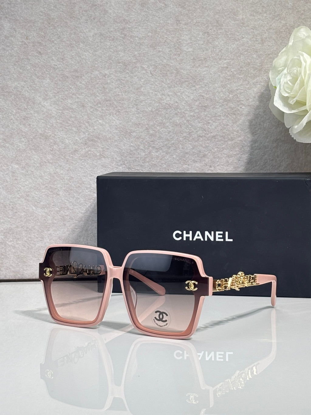 Chanel sunglasses with light pink square frames and gold-tone logo hardware