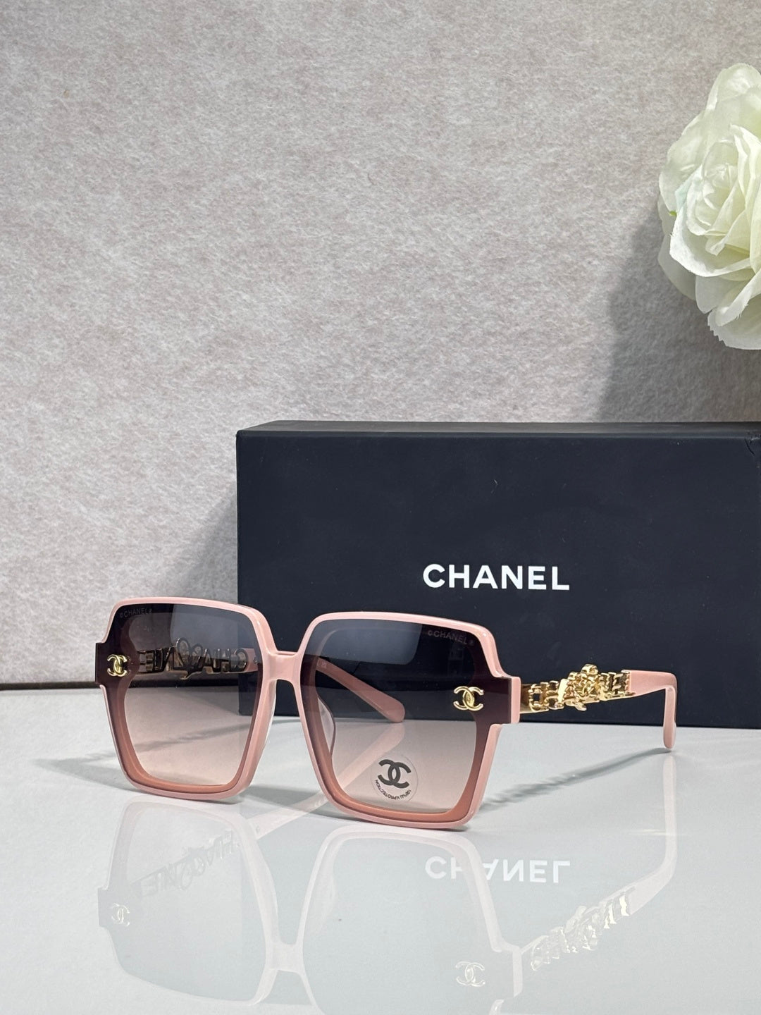 Chanel sunglasses with light pink square frames and gold-tone logo hardware