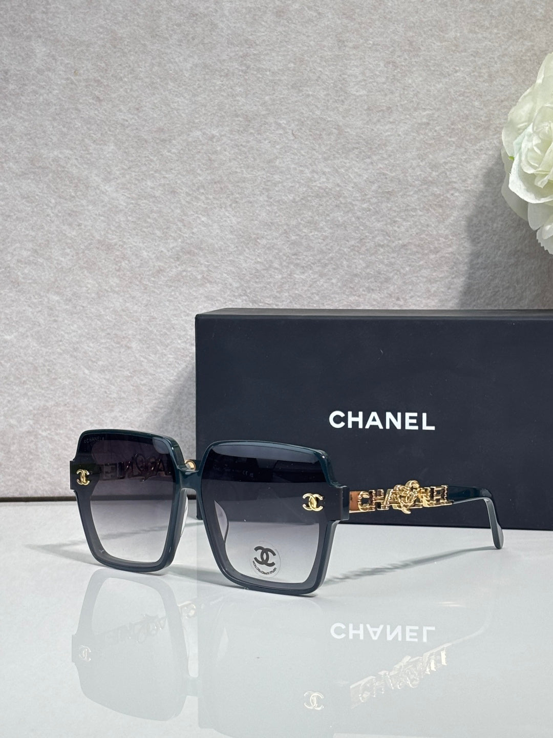 Chanel sunglasses with dark navy square frames and gold-tone logo hardware