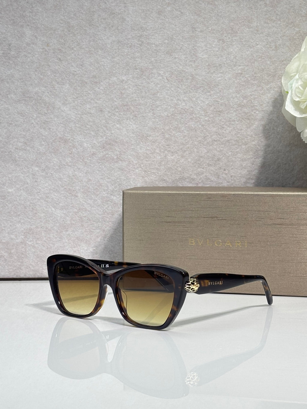 Bvlgari sunglasses, black frame with brown-tinted lenses and gold emblem detail