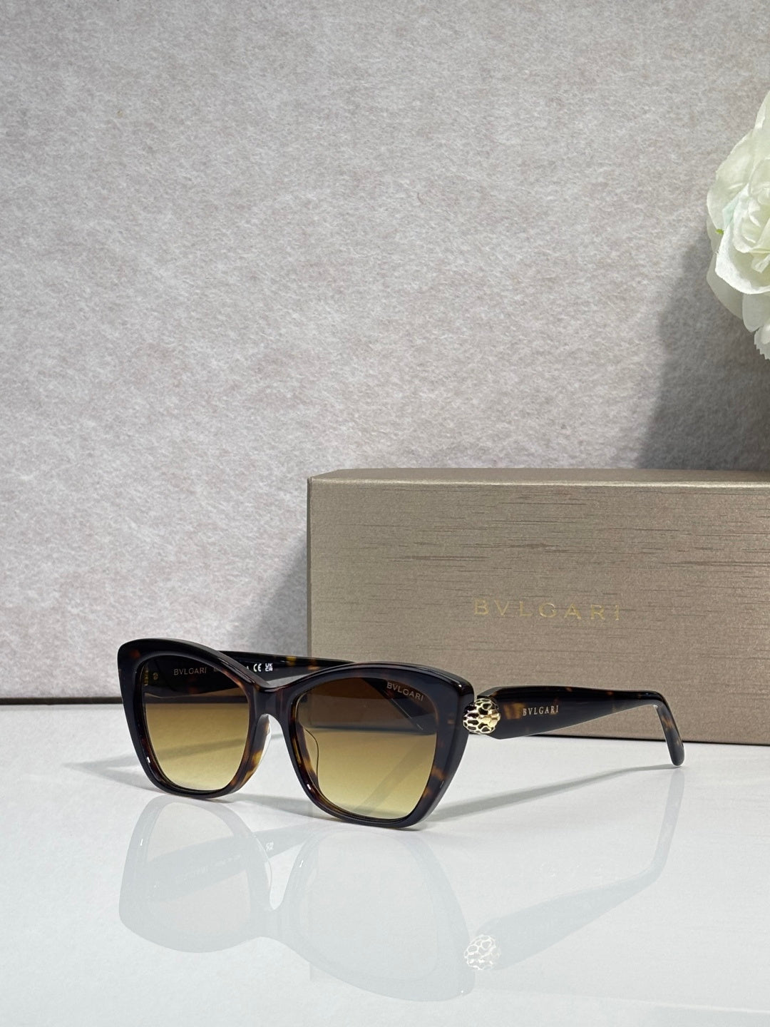 Bvlgari sunglasses, black frame with brown-tinted lenses and gold emblem detail
